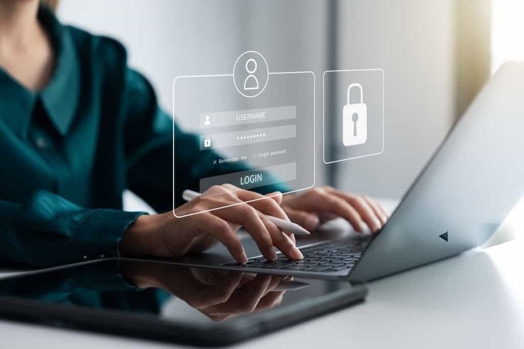 Person using a laptop with digital lock overlay representing cybersecurity for freelancers and small businesses