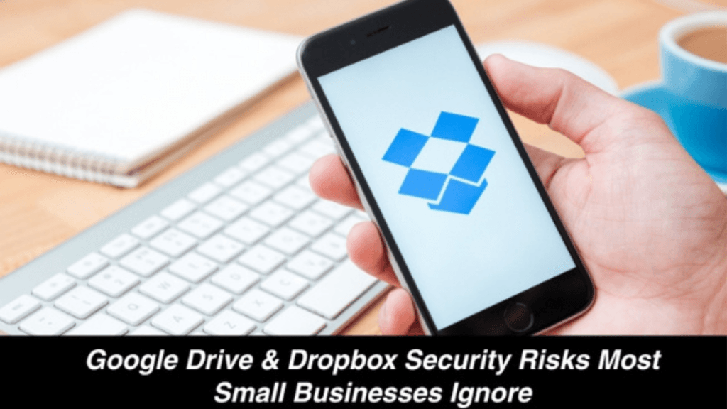 Smartphone displaying the Dropbox logo with a keyboard and coffee cup on a desk, illustrating Google Drive security risks for small businesses.
